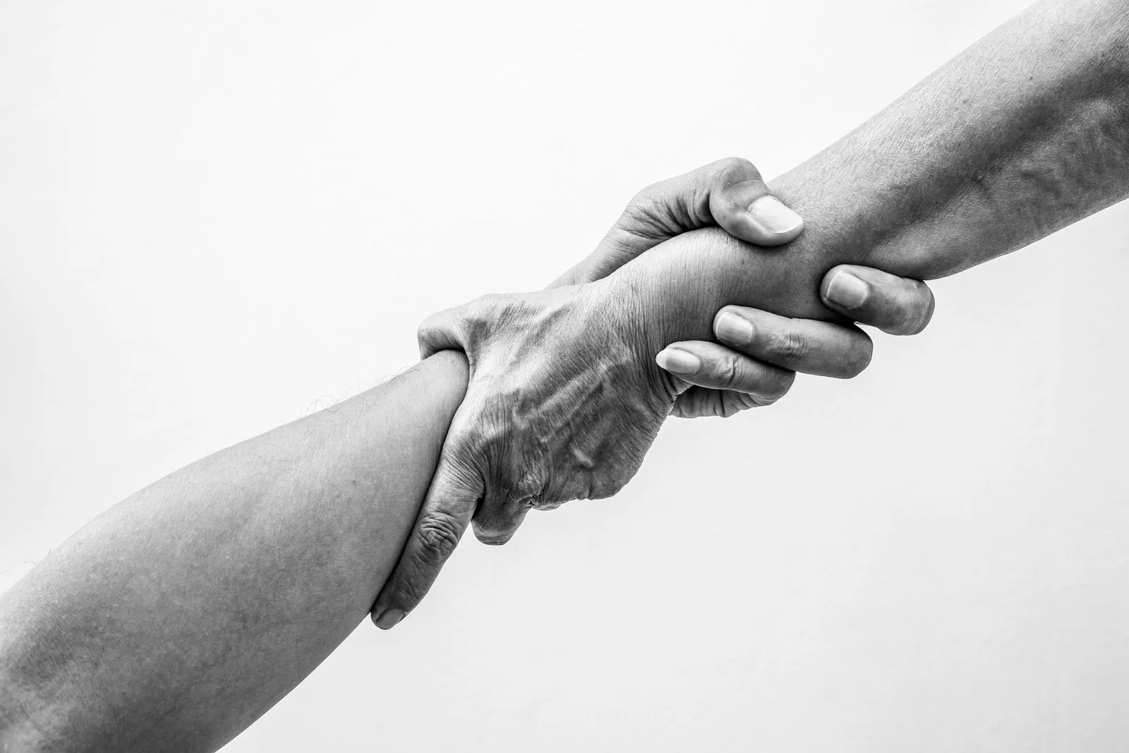 Zwei Hände greifen einander am Unterarm als Symbol für Unterstützung gemeinnütziger Projekte