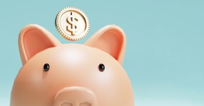 Eine Münze fällt in ein Sparschwein. Der erste Schritt zur Startup-Finanzierung.